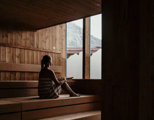 Sauna Eine Frau sitzt auf einer Holzbank.