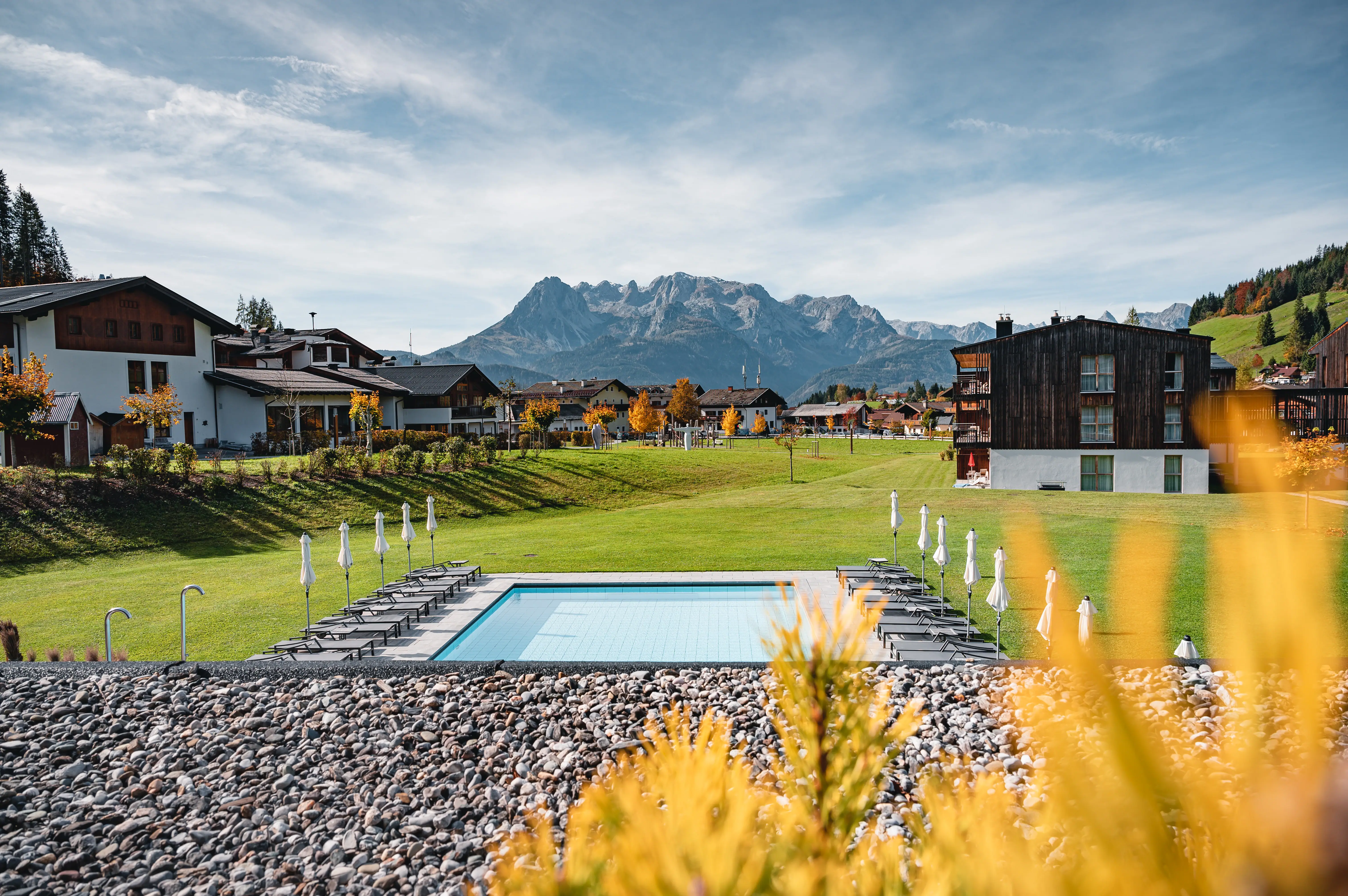 Ausblick Werfenweng Ein Pool in einer grasbewachsenen Gegend mit Bergen im Hintergrund.