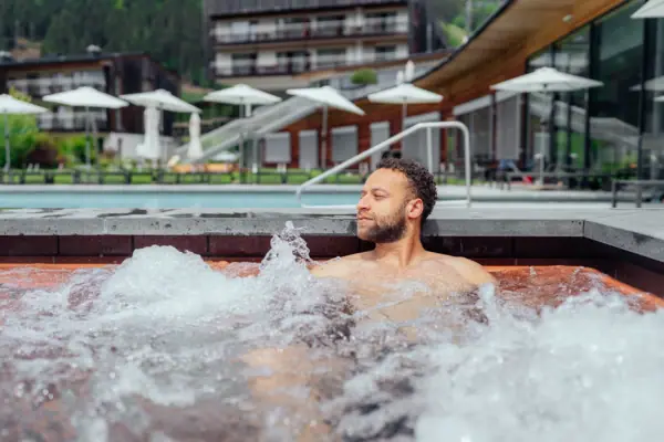 Whirlpool Ein Mann in einem Whirlpool im Freien.