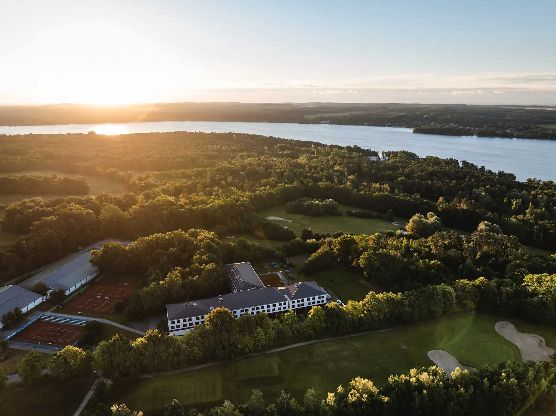 aja Bad Saarow Großer Gewässer mit einem Gebäude und Bäumen im Vordergrund.