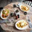 Essen und Trinken Ein gedeckter Tisch zum Abendessen mit Tellern auf denen Gerichte angerichtet sind