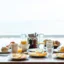 Frühstück Ein gedeckter Frühstückstisch mit Pancakes, Brötchen und Früchten sowie Säften und Kaffee.