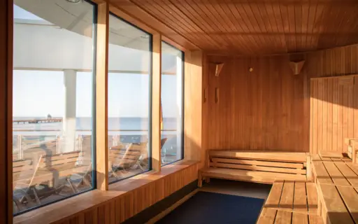 Eine Holzsauna mit Blick auf den Pool und den dahinter liegenden Strand. Eine Holzsauna mit Blick auf den Pool und den dahinter liegenden Strand.