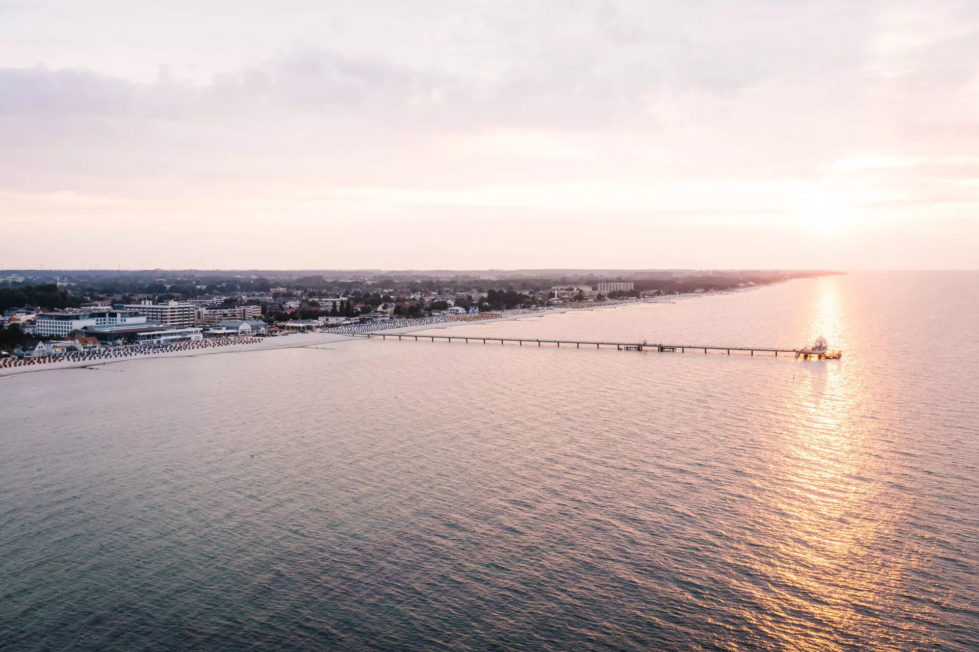 Seebrücke Grömitz Ein langer Wasserlauf mit einem Pier und Gebäuden im Hintergrund