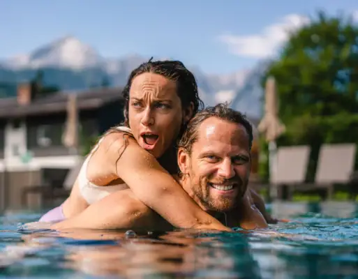 Paar im Pool Ein Mann und eine Frau im Pool, lächelnd.