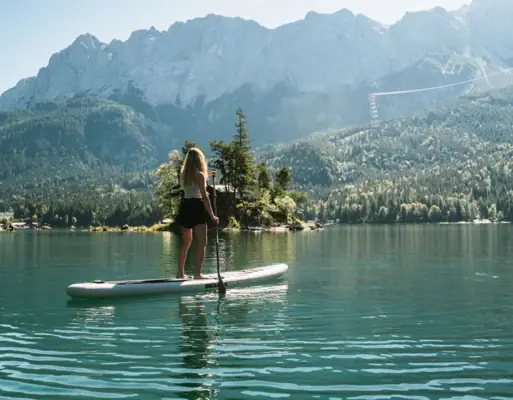 Stand-Up-Paddling Eine Frau auf einem Paddleboard auf einem See.