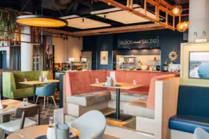 aja Restaurant Ein Restaurant mit Tischen und Stühlen im Innenbereich.