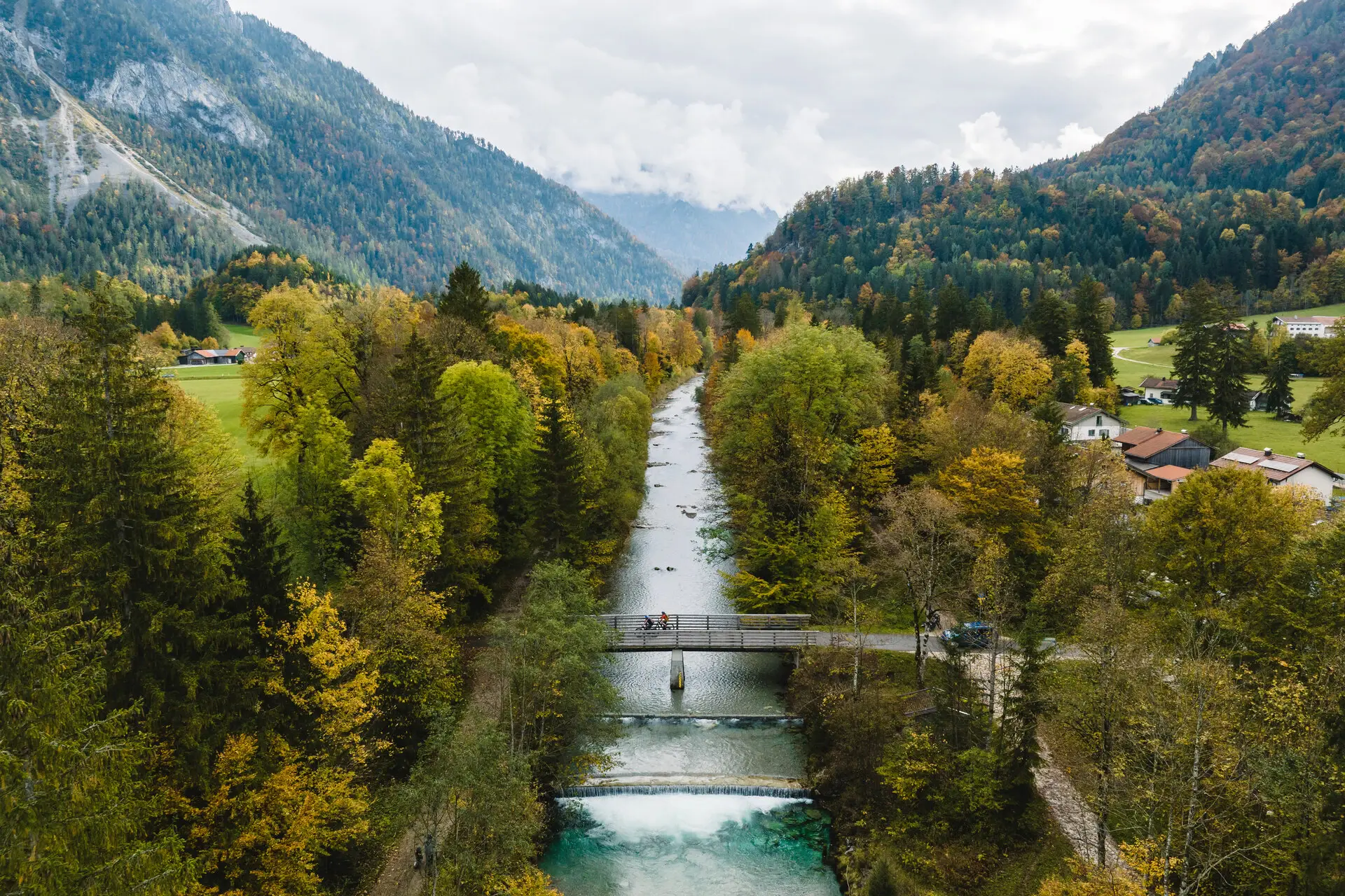 Ruhpolding Brücke über einen Fluss umgeben von Bäumen.