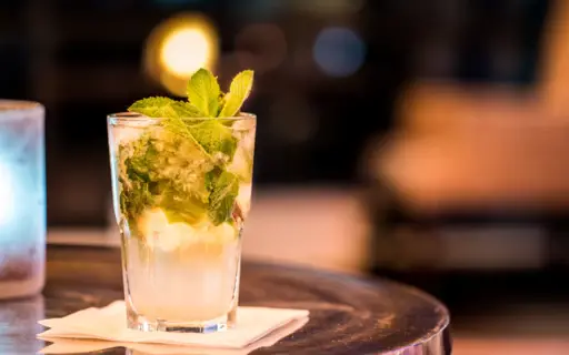 Ein Mojito steht auf einem kleinen Tisch. Ein Mojito steht auf einem kleinen Tisch.