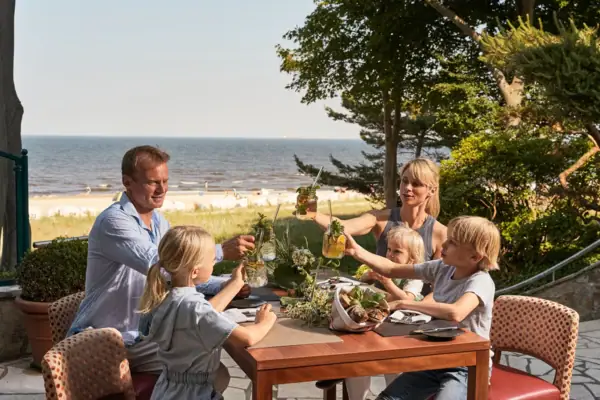 Familienurlaub Eine Gruppe von Menschen sitzt an einem Tisch mit Getränken.