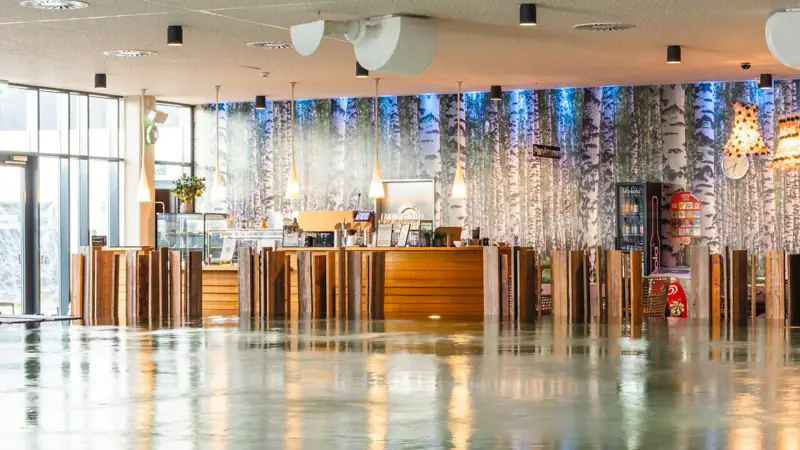 Poolbar Ein großer Raum mit einem Tresen und einer großen Wand mit Bäumen.