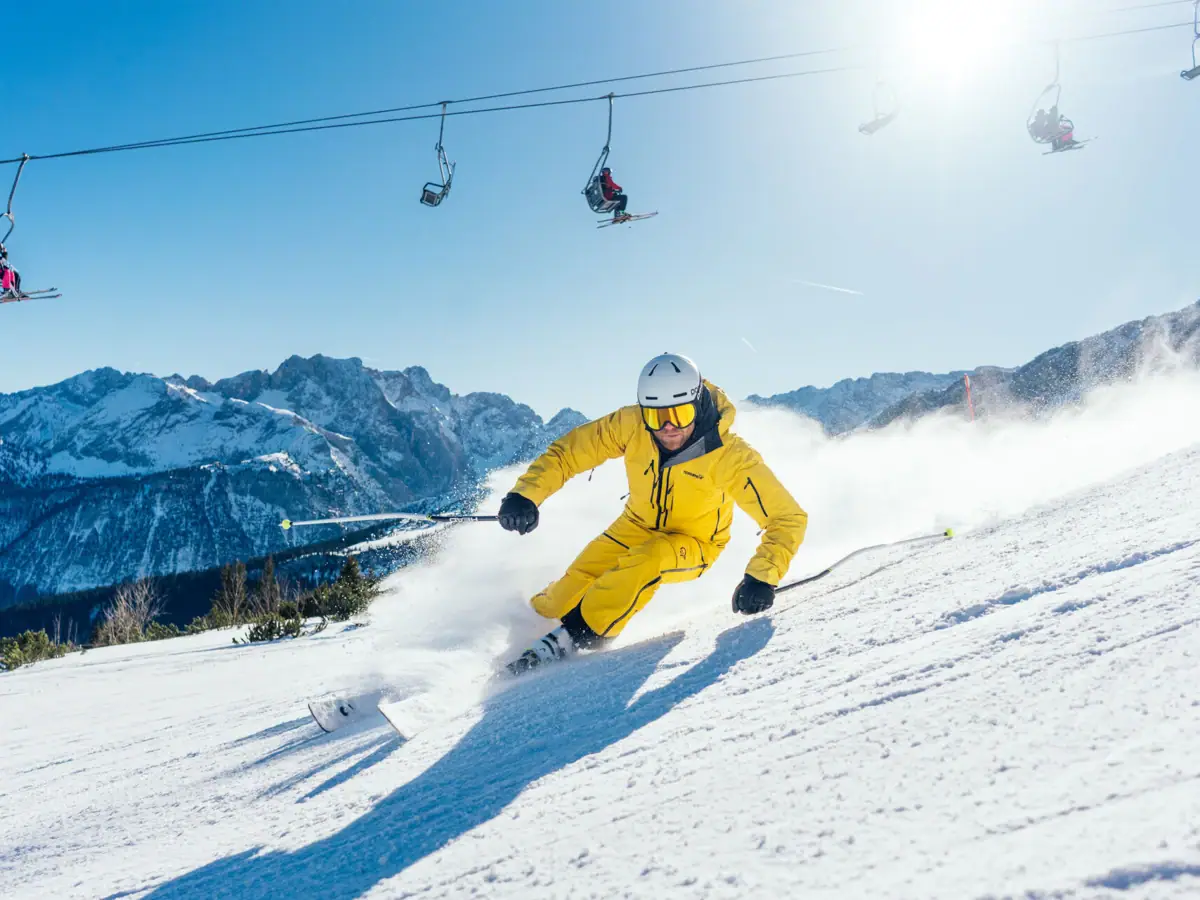 Skifahrer Eine Person fährt auf Skiern einen schneebedeckten Berg hinunter.