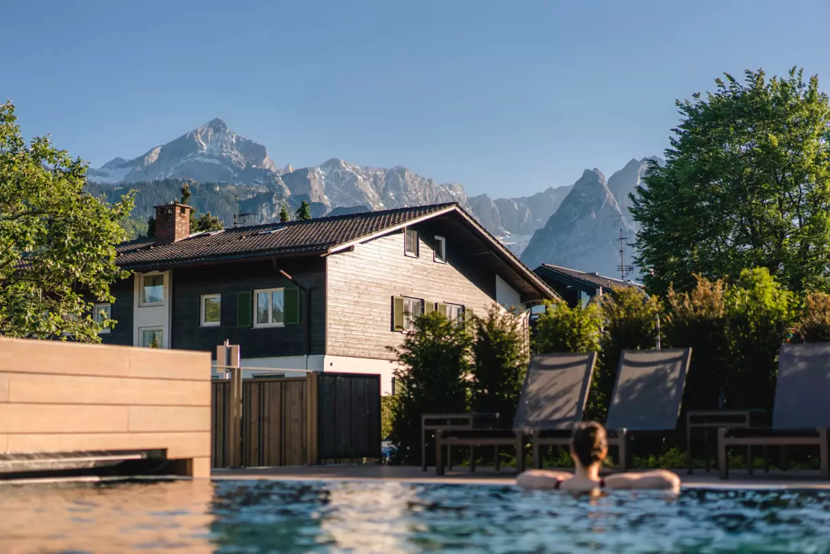 Aussenpool Eine Person in einem Pool vor einem Haus.