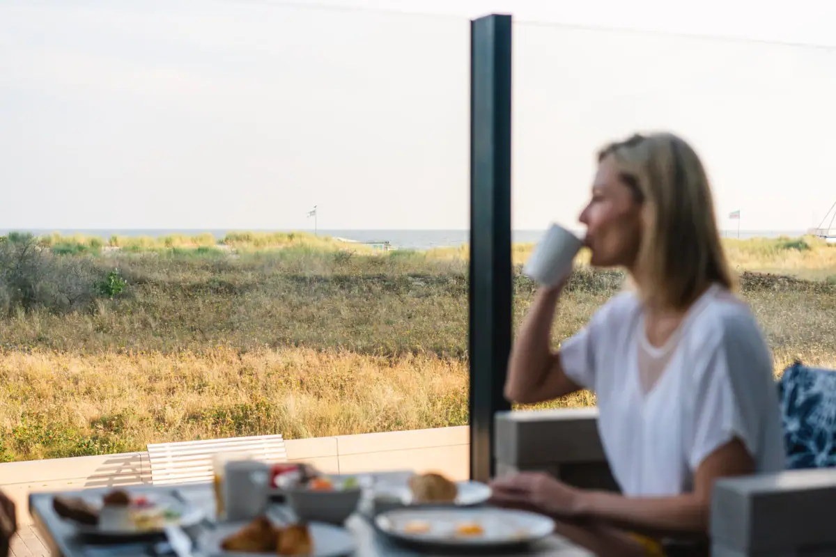 Eine Frau sitzt an einem Tisch mit einer Tasse Kaffee.