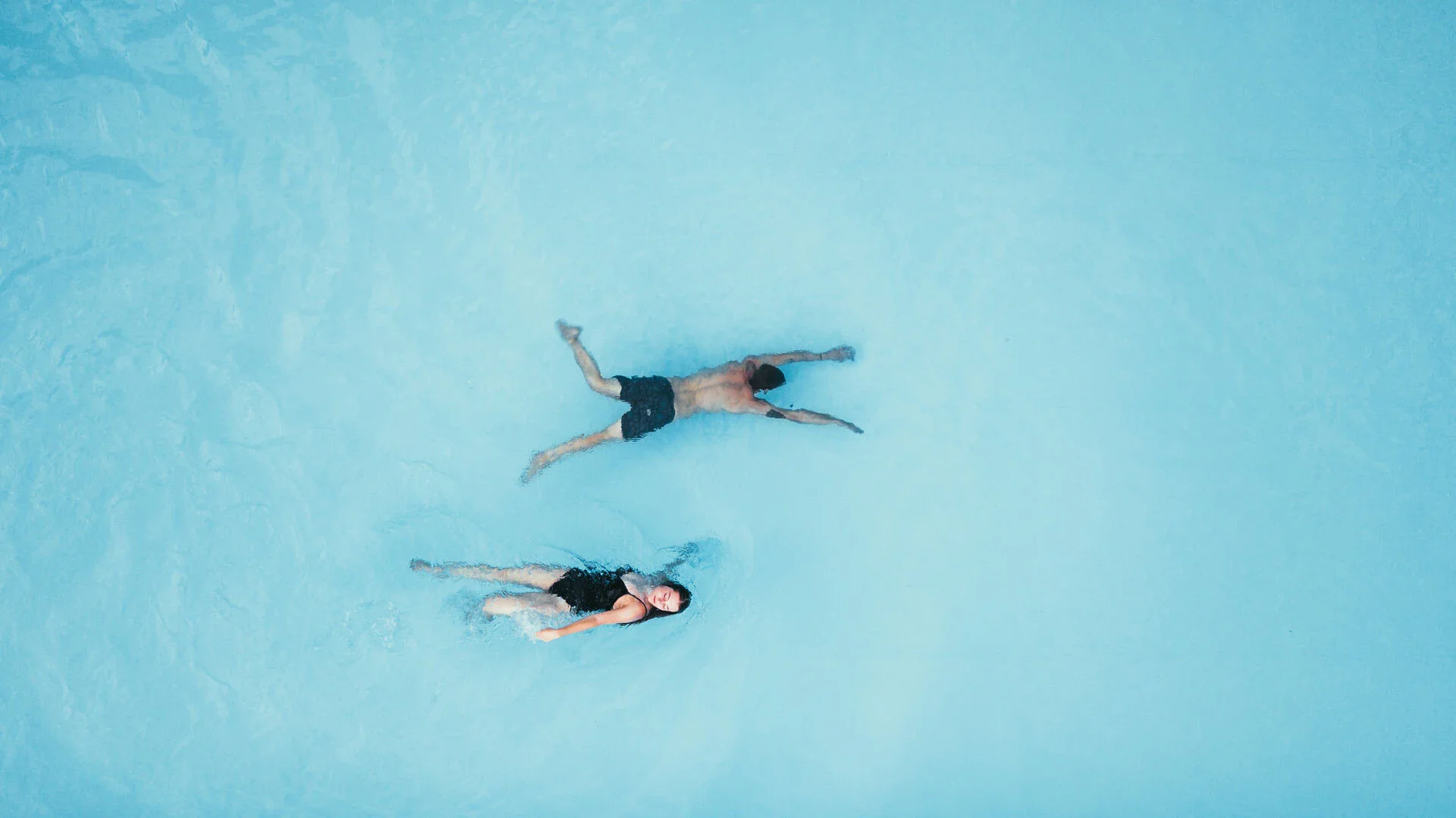 Eine Luftaufnahme von einem Pool, in dem zwei Personen schwimmen.