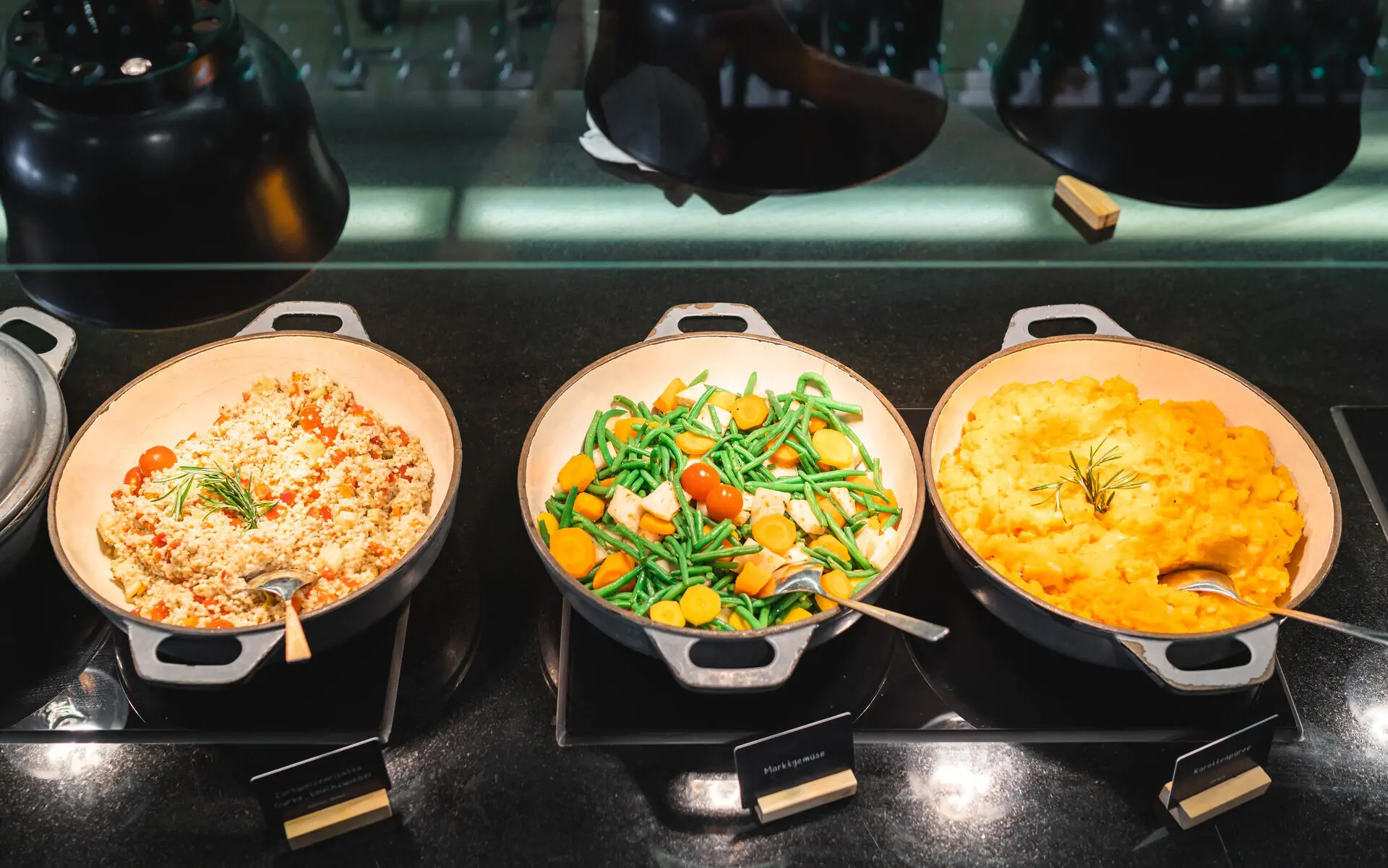 vegetarisches Gericht Ein Buffetbereich mit drei Töpfen gefüllt mit unterschiedlichen vegetarischen Speisen.