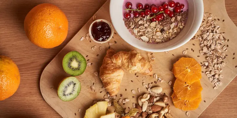 Ein Brett mit Obst und Nüssen auf einer Holzoberfläche. Ein Brett mit Obst und Nüssen auf einer Holzoberfläche.