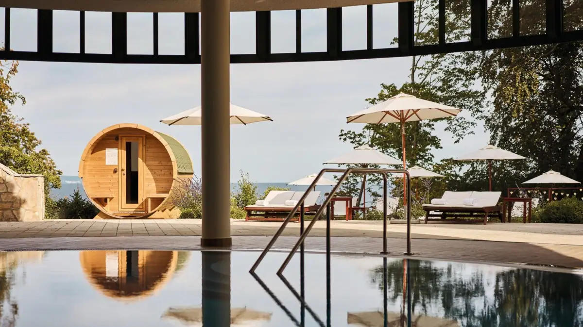 Ein Pool mit Sonnenschirmen und einem Fass.