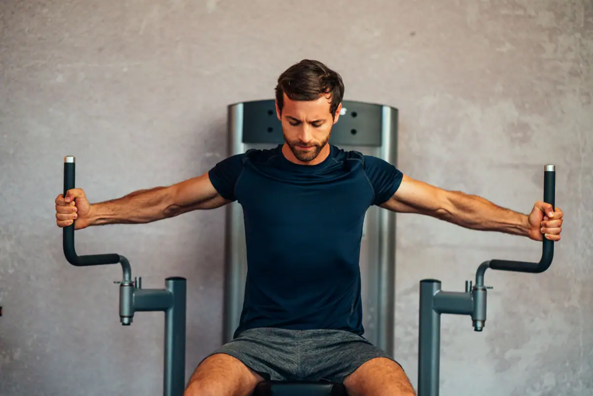 Ein Mann trainiert an einem Fitnessgerät.