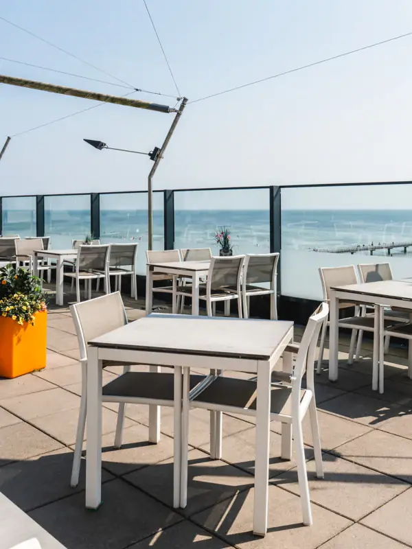 Ein Tisch und Stühle auf einer Terrasse.