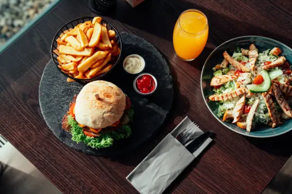 Bargerichte Ein Teller mit Fast Food auf einem Tisch.