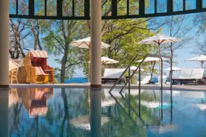 SPA Ein Pool mit einem Liegestuhl und Sonnenschirmen.