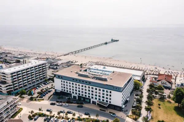 aja Grömitz Ein Gebäude neben einem Strand.