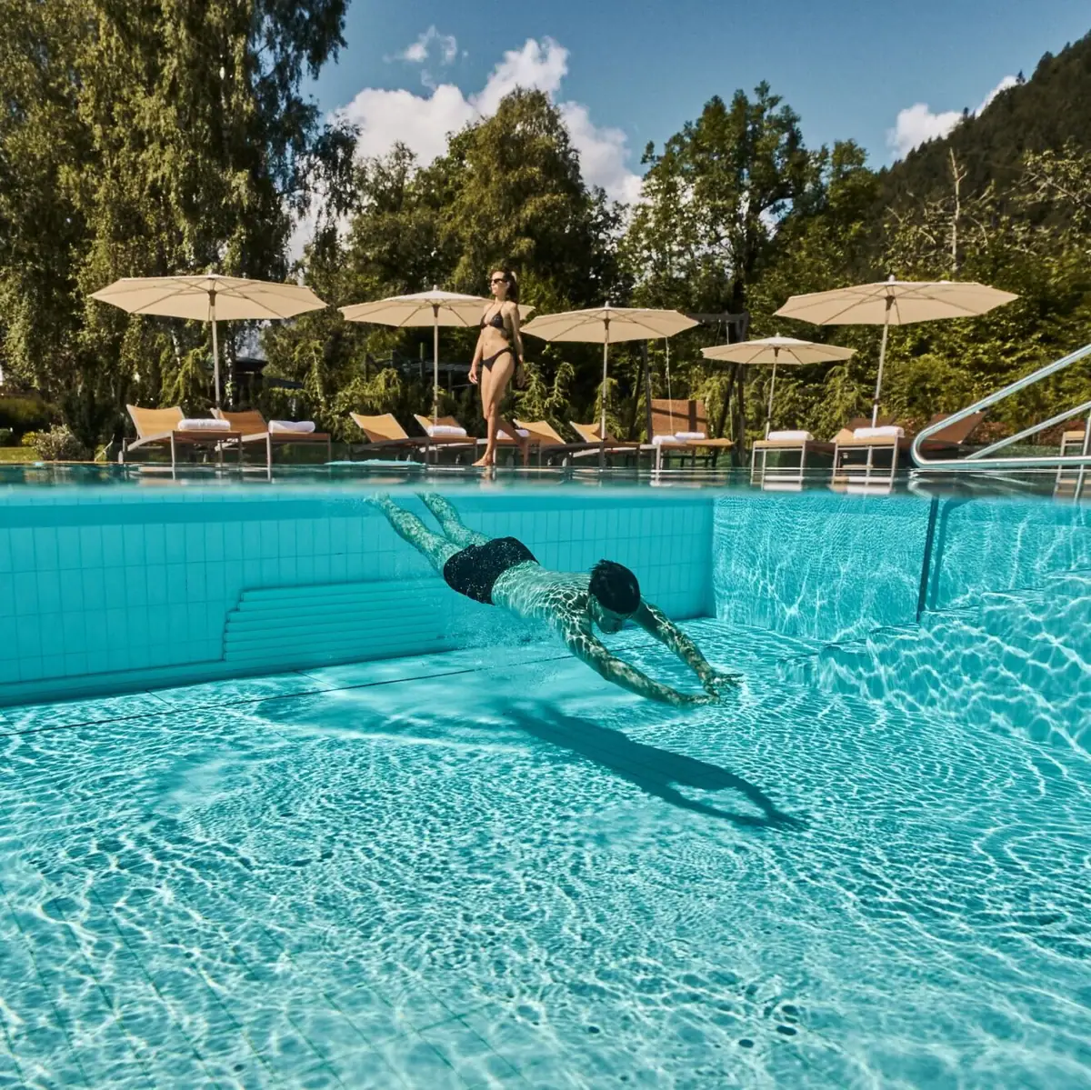 Außenpool Ein Mann schwimmt in einem Pool.