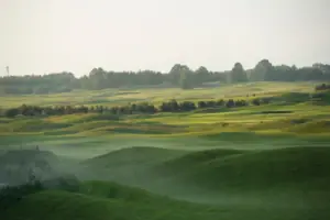 Golfplatz Grünes Feld mit Bäumen und blauem Himmel