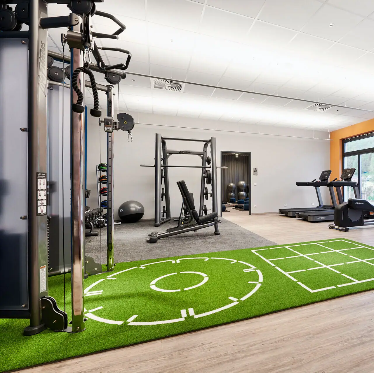 Fitnessbereich im aja Ruhpolding Ein Fitnessstudio mit Trainingsgeräten.
