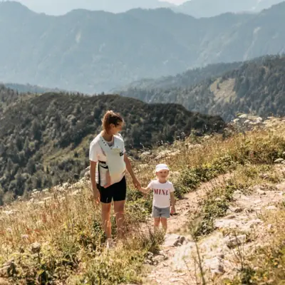 Wandern mit Kindern Eine Frau und ein Kind beim Wandern auf einem Berg.
