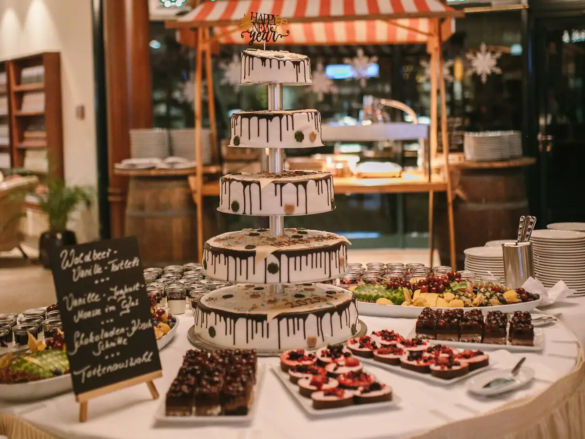 Silvester im aja Strandhotel Bansin Dessertbuffet mit einer mehrstöckigen Torte sowie kleinen Süßspeisen auf einem Tisch angerichtet