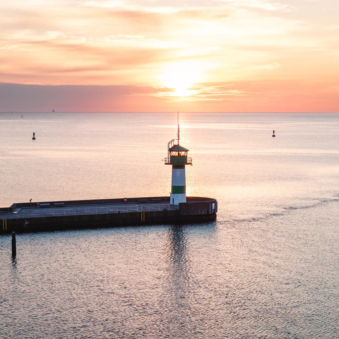 Ein Pier mit einem Leuchtturm im Wasser.