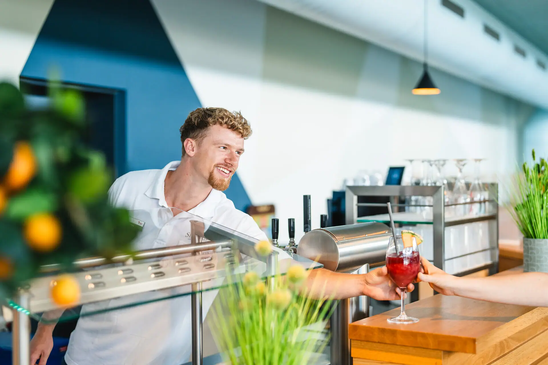 Poolbar Ein Mann reicht einer Frau ein Getränk.