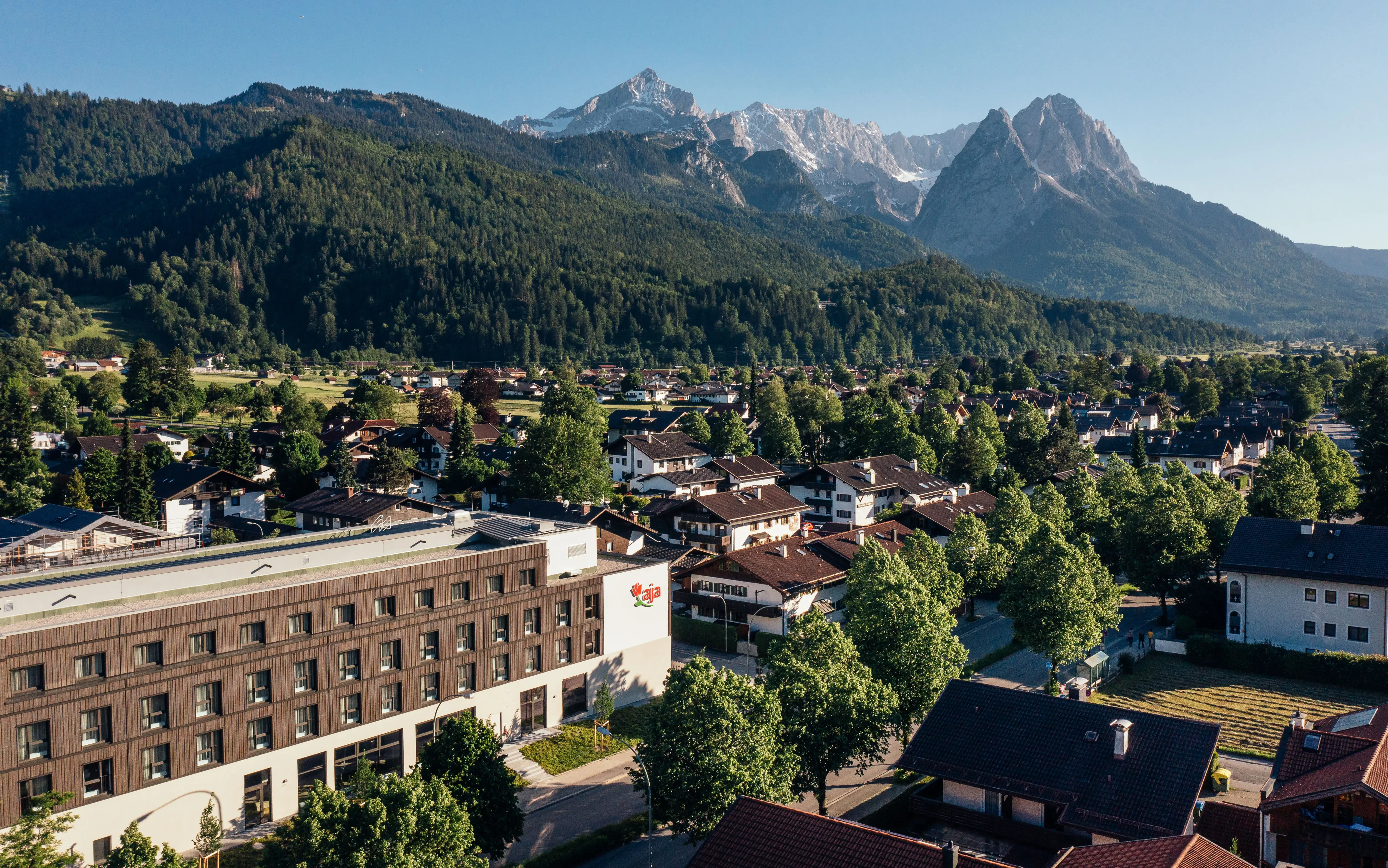 Stadtlandschaft mit Bäumen und Bergen im Hintergrund