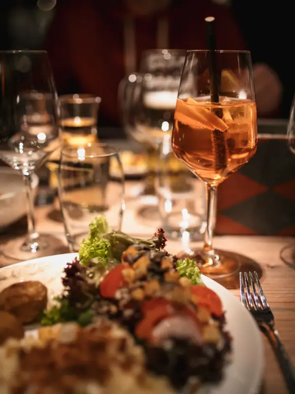 Essen im Restaurant Ein Teller mit Essen und ein Weinglas mit Getränk auf einem Tisch.