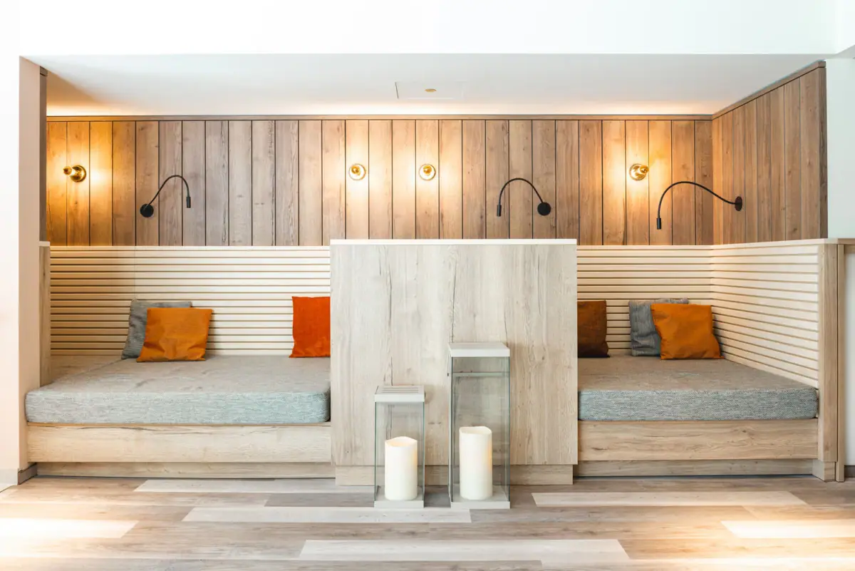 Ruheraum Ein Raum mit einer Holzwand und zwei Lampen.