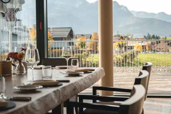 Feinspitz Ein Tisch mit Tellern und Gläsern darauf, in einem Außenbereich.