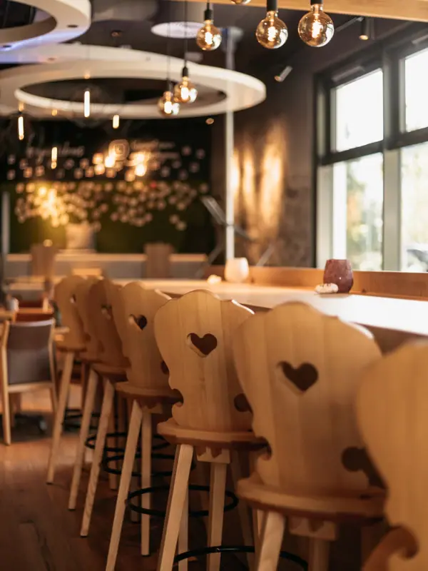Barstühle Die aja Bar Garmisch-Partenkirchen mit Stühlen und Tischen.