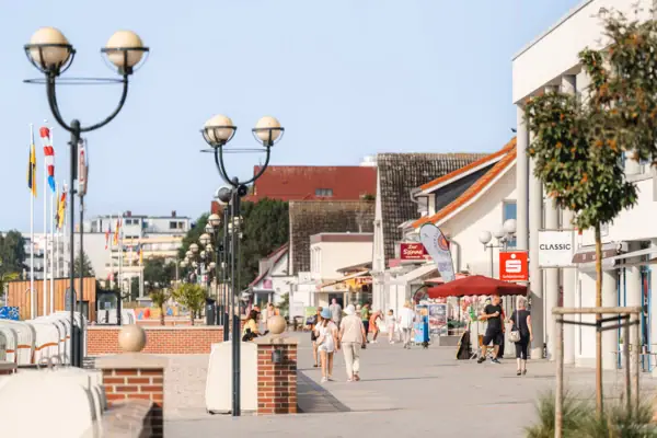 Promenade Eine Gruppe von Menschen, die auf einem Gehweg spazieren gehen.