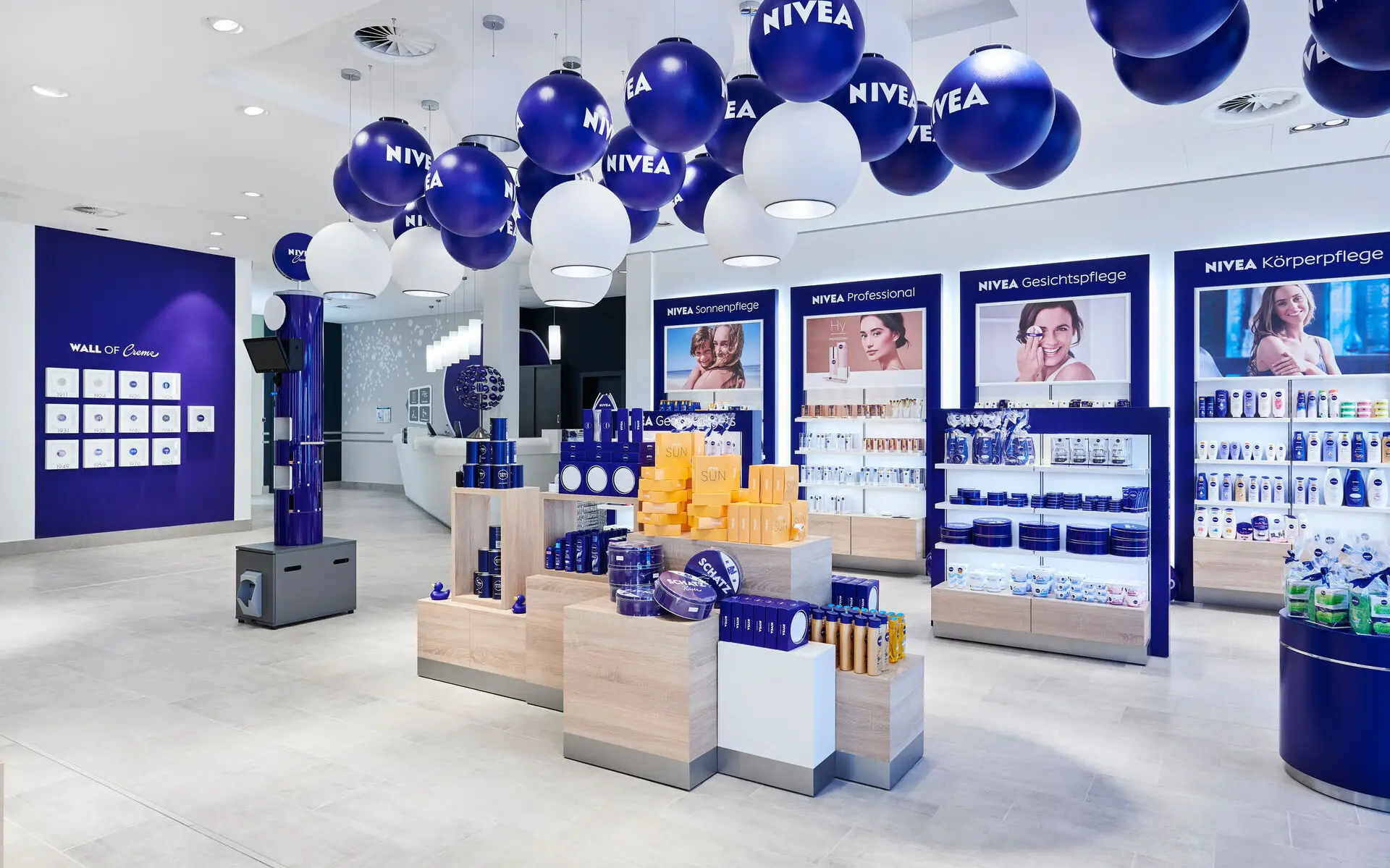Innenansicht eines NIVEA Shops mit vielen blauen Aufstellern und Regalen, gefüllt mit Produkten.