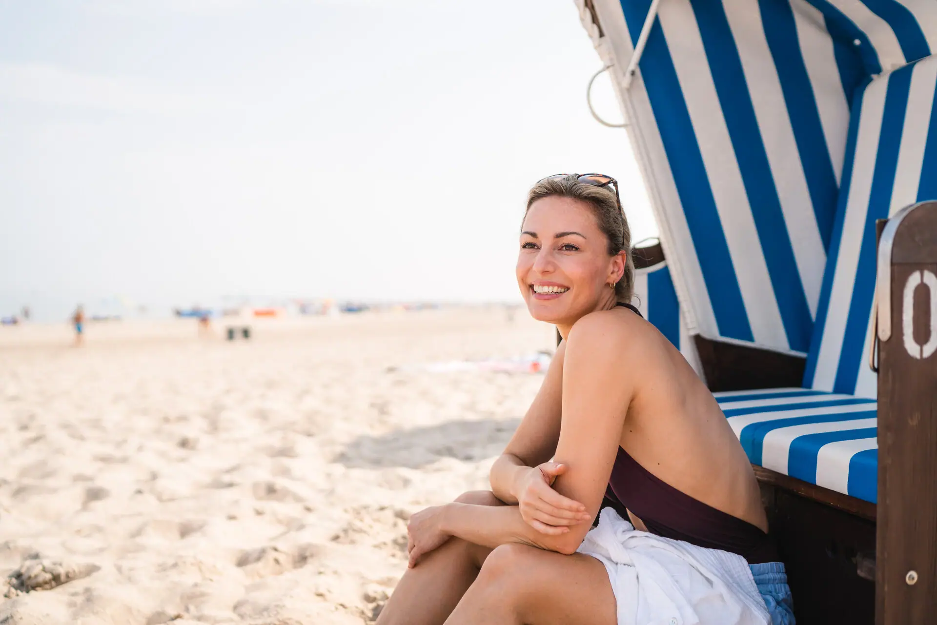 Strandkorb Eine Frau sitzt in einem Strandkorb.