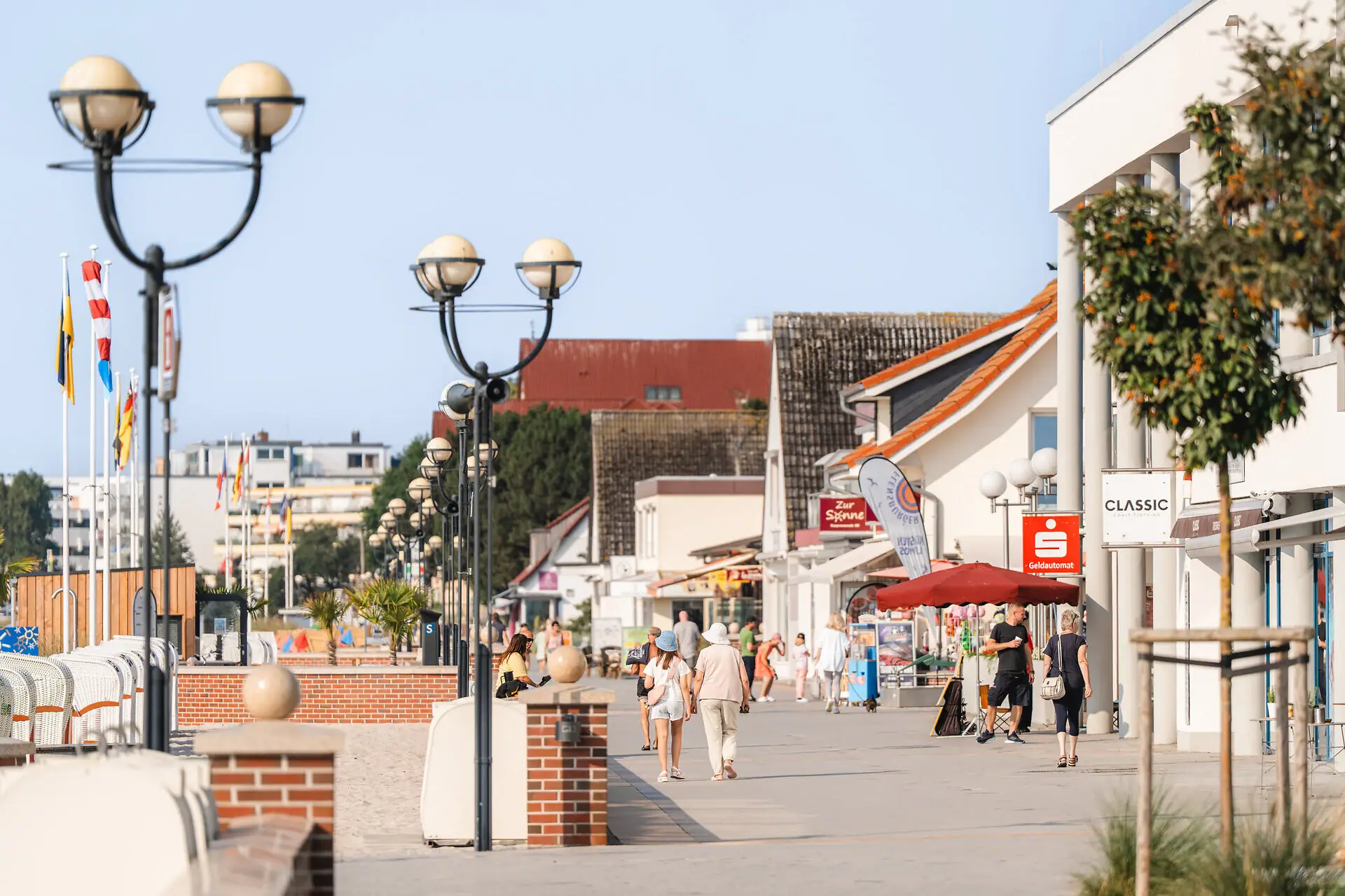 Promenade Eine Gruppe von Menschen, die auf einem Gehweg spazieren gehen.