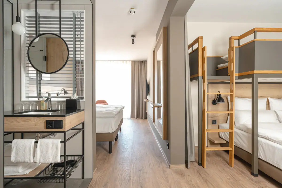 Familienzimmer Ein Zimmer mit einem Etagenbett und einem Spiegel.