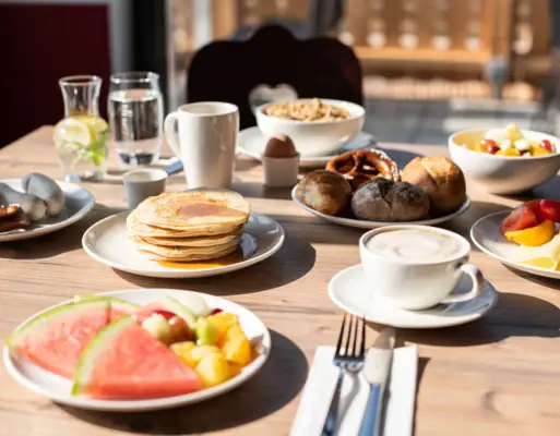 Frühstück in Ruhpolding Ein Tisch mit Tellern voller Speisen und Getränken.