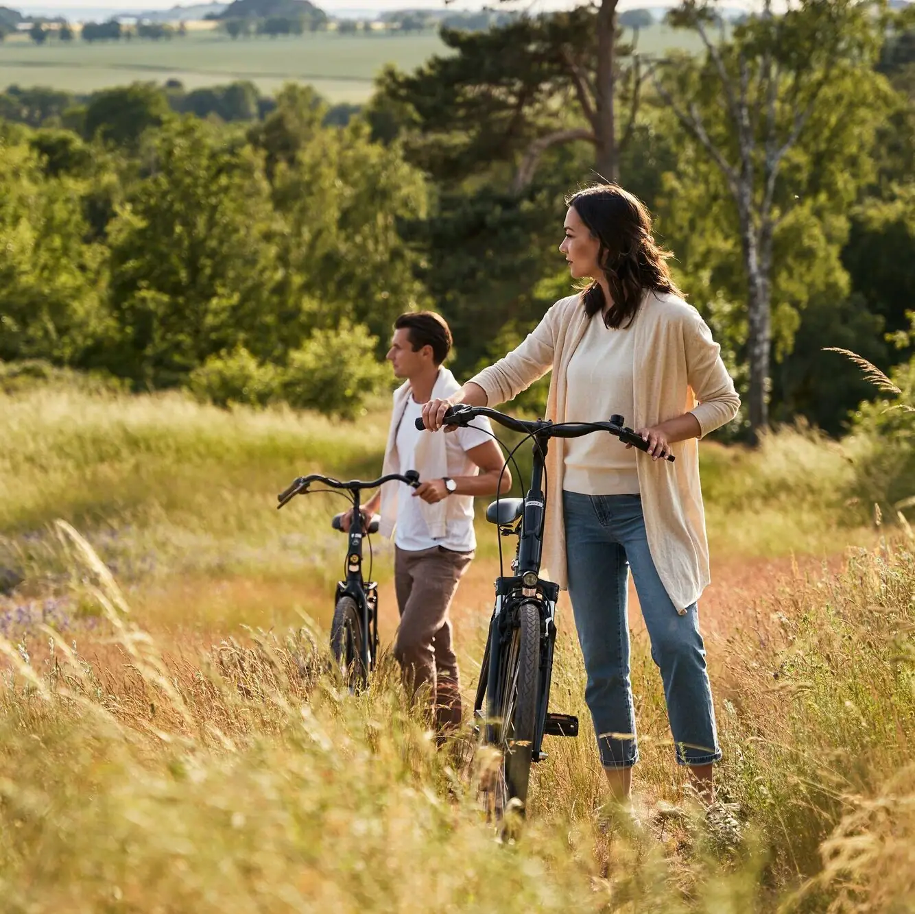 Fahrradtour Rügen Eine Frau und ein Mann fahren mit Fahrrädern durch ein Feld.