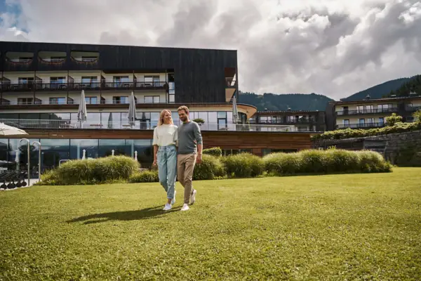 Ein Mann und eine Frau gehen auf einem Rasen.