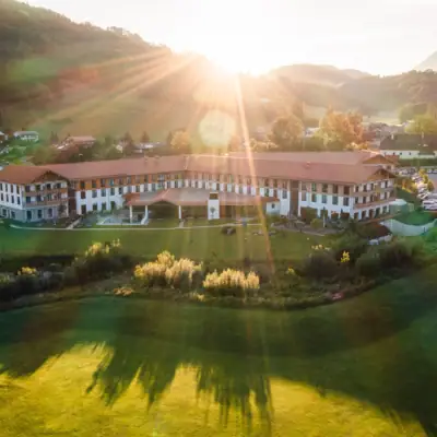 aja Ruhpolding Großes Gebäude mit Rasen und Parkplatz im Vordergrund.