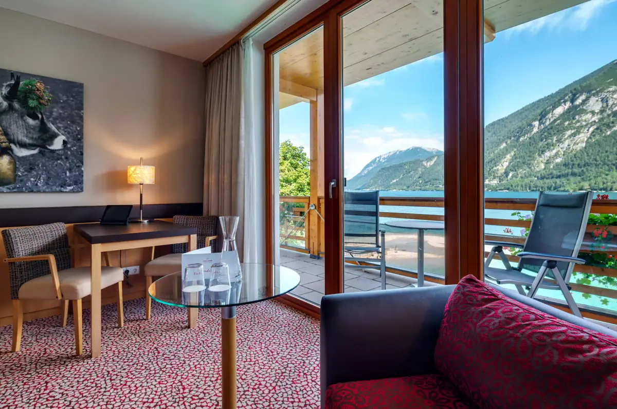 Zimmer mit Seeblick Ein Raum mit einem Glastisch und Stühlen.