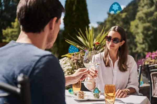 Anstoßen Ein Mann und eine Frau halten Weingläser an einem Tisch.